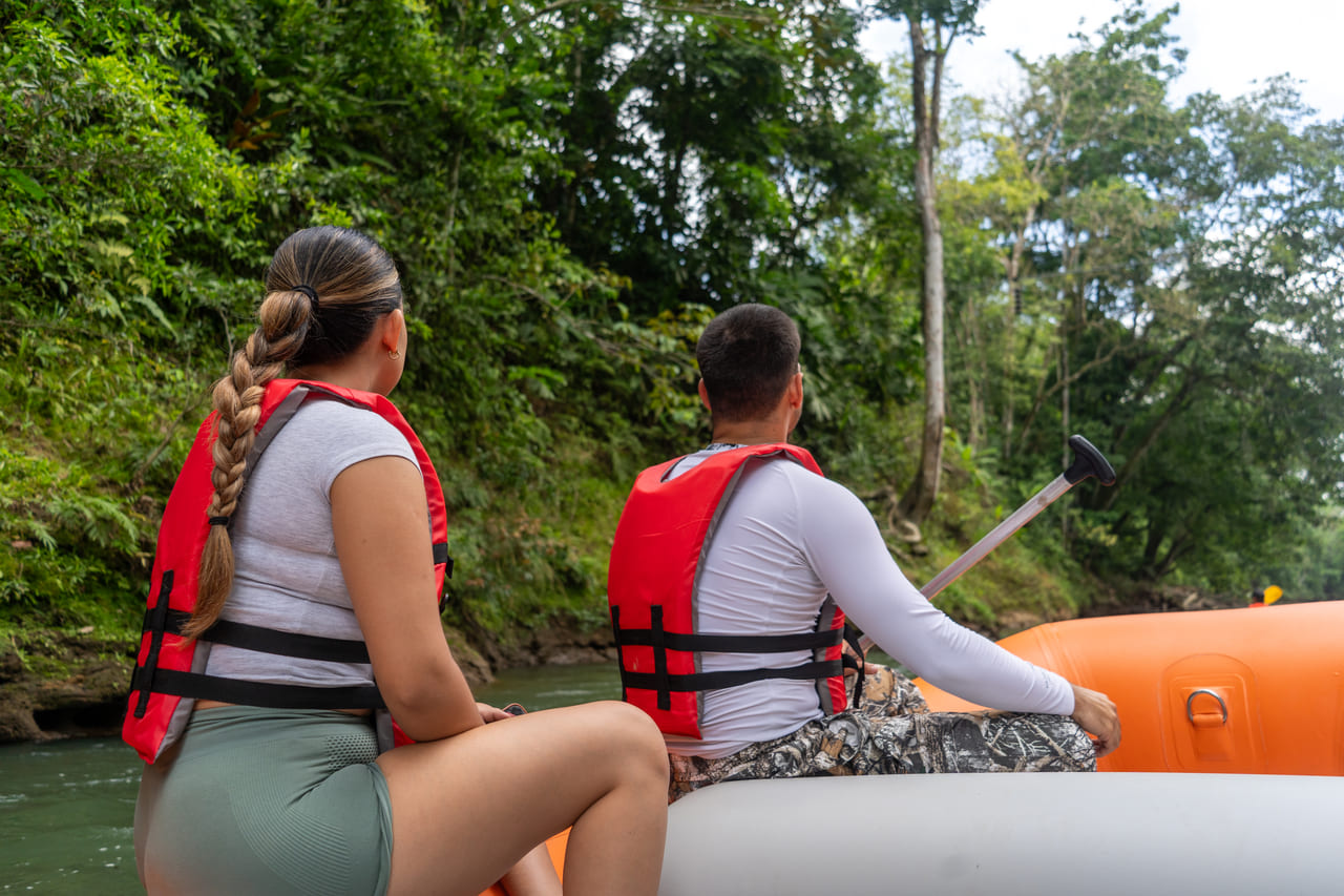 Pareja invitada de espaldas remando junto al guía sobre el Río Peñas Blancas