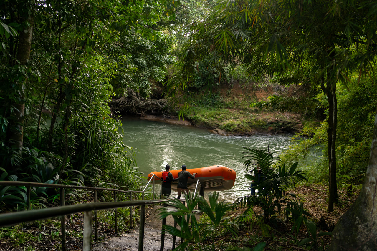 Raft inflable naranja amarrado al pie de las escaleras del embarcadero del Río Peñas Blancas